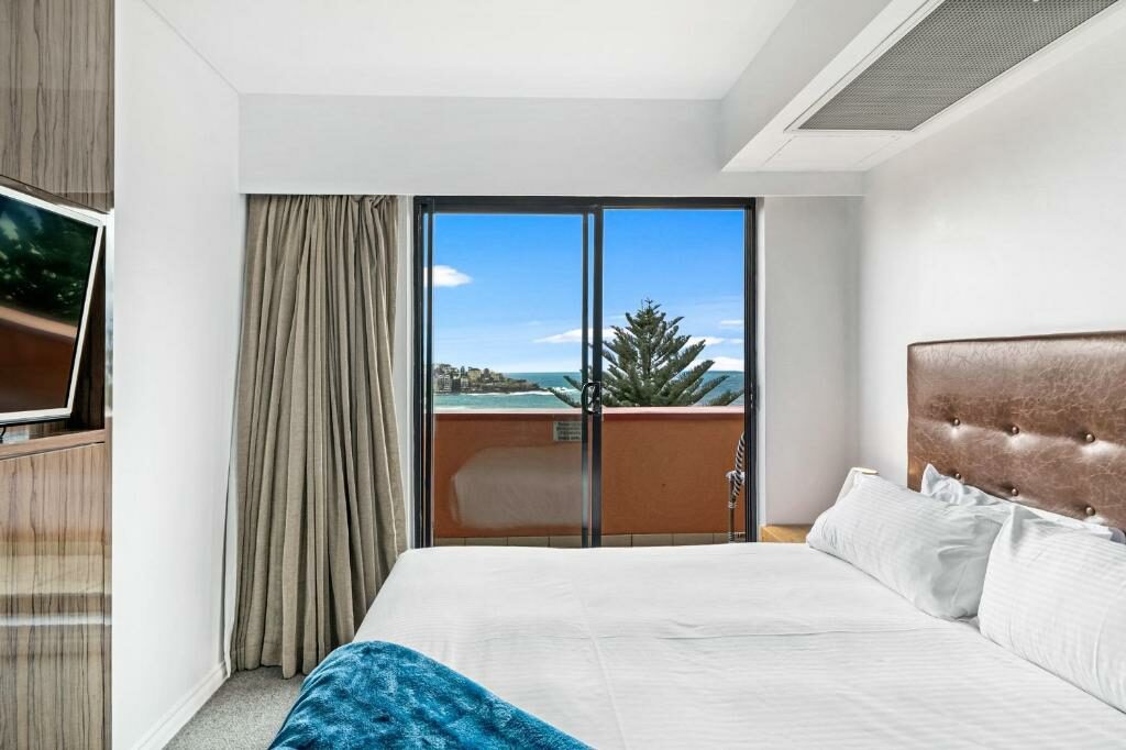 A bedroom at the Bondi 38 Serviced Apartments with an ocean view.